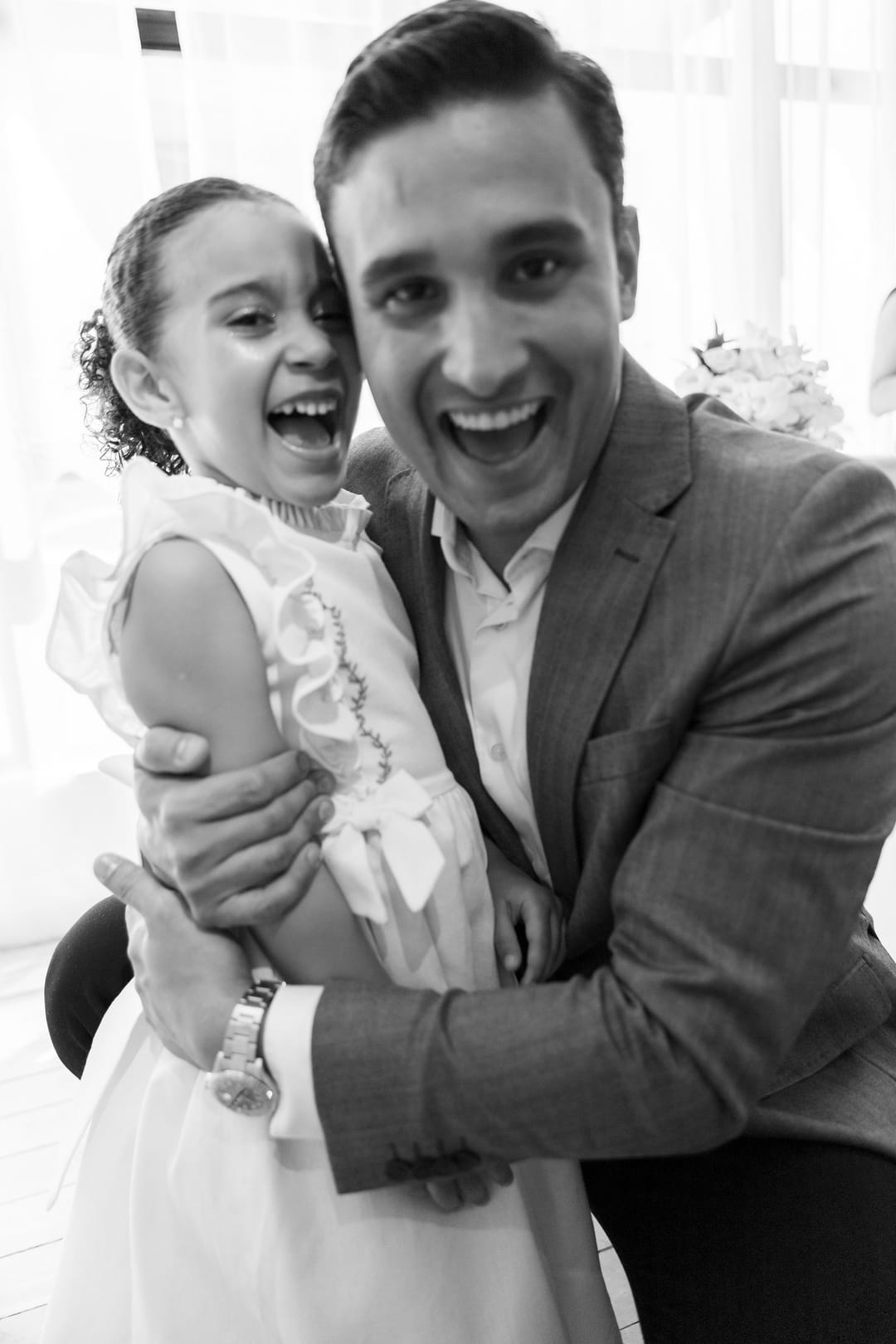 Em preto e branco, o noivo abraça a filha, e os dois gargalham para a câmera.