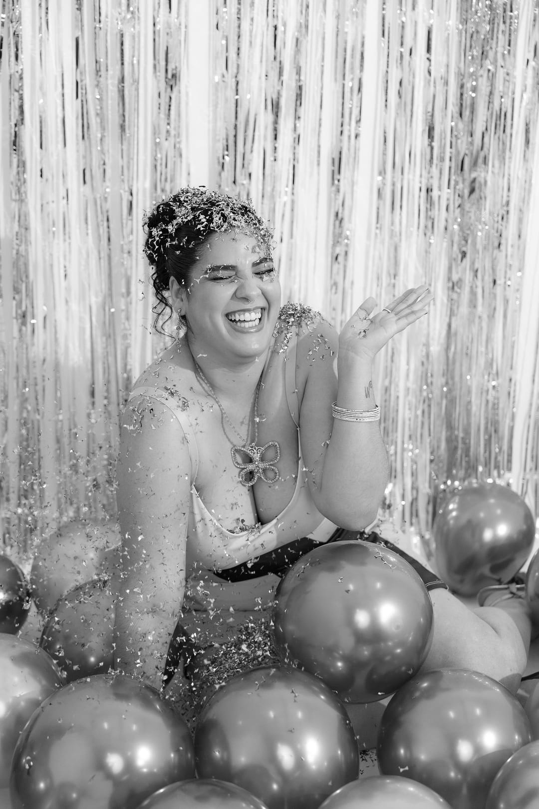 Ela gargalha com a mão erguida sob uma chuva de confete cor de cobre.